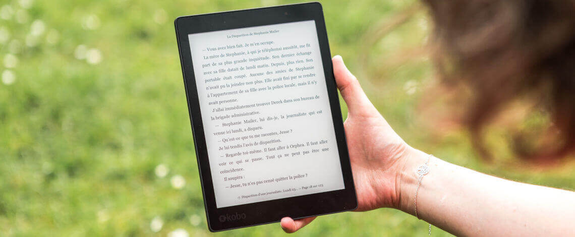 Detalhe de mão lendo um livro digital em um tablet